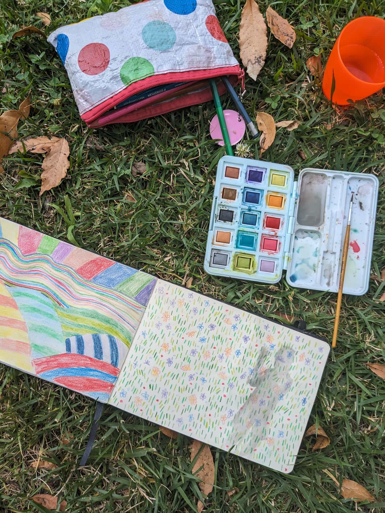 schetsboek en kleurenpallet op gras
